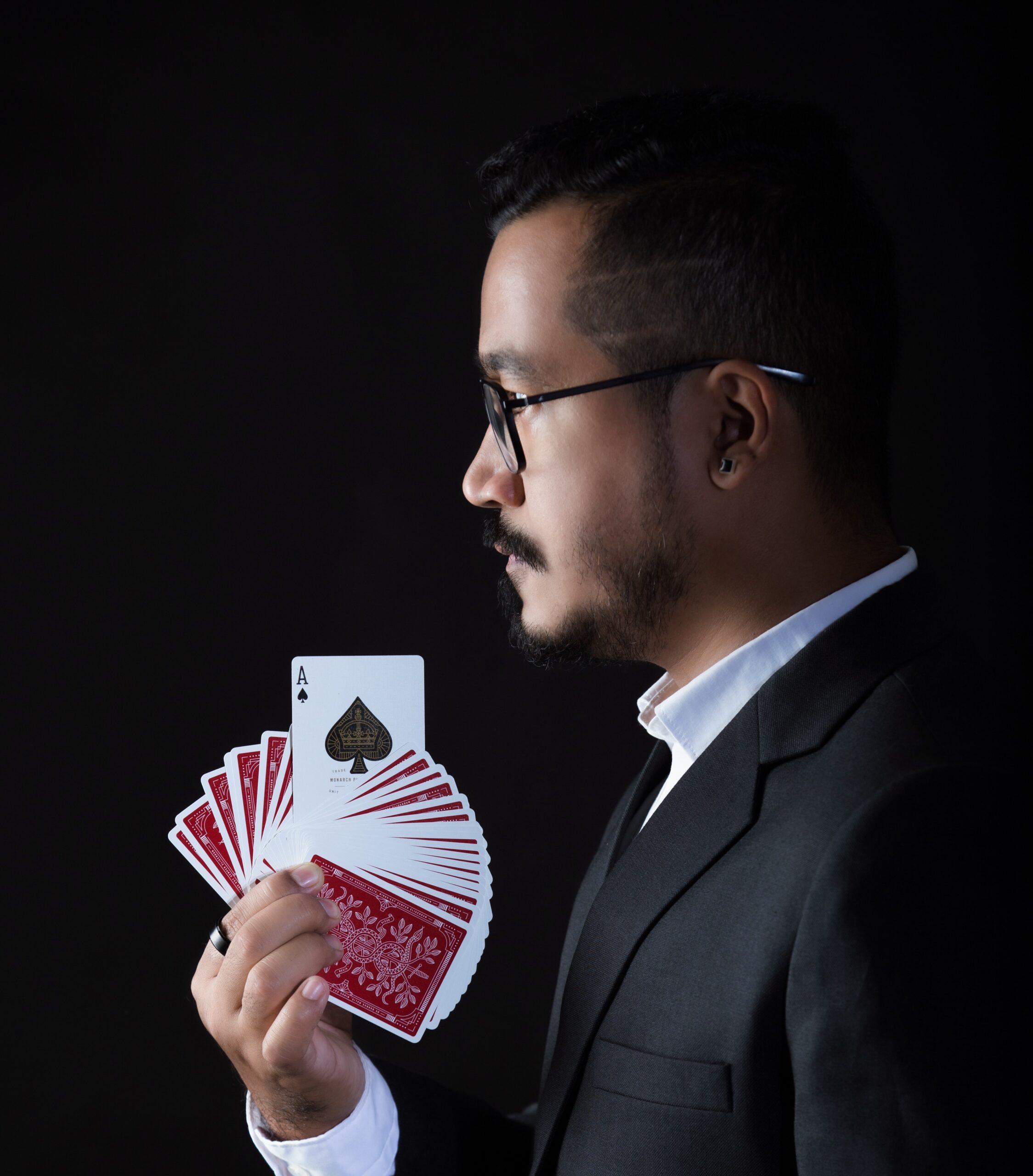 Magician And Mentalist Kunal Newar holding cards with Ace card being visible